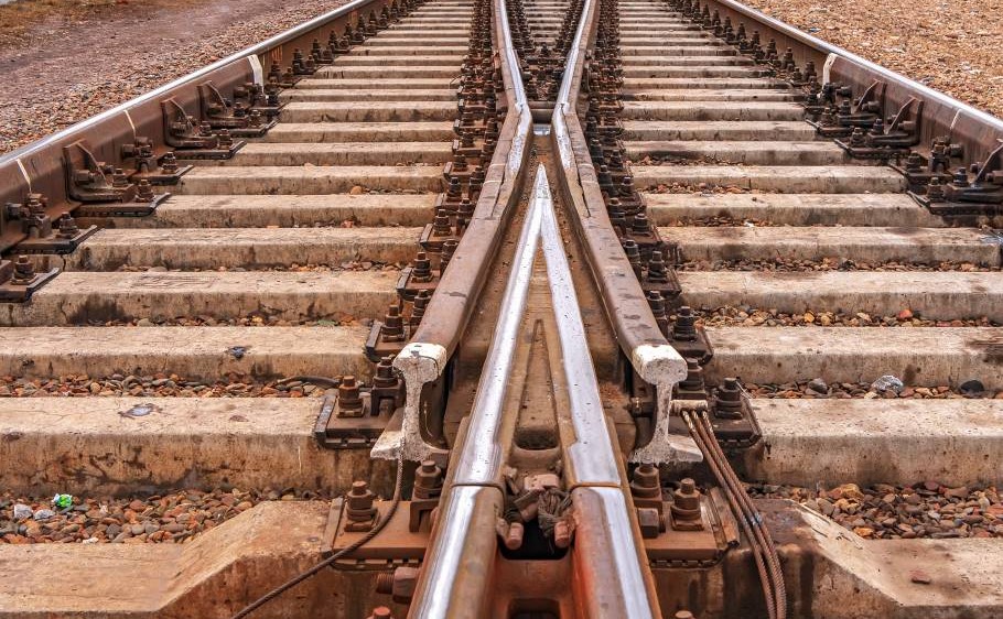 Two train tracks come together through a frog, which looks like an arrow’s head between two converging track points.