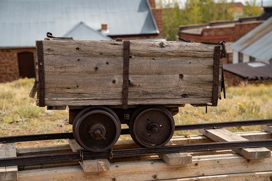 An old mining cart sits on rails at a mining museum