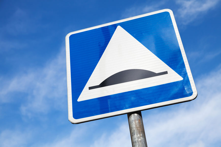 panneau de signalisation carré d’un dos d’âne devant un ciel bleu