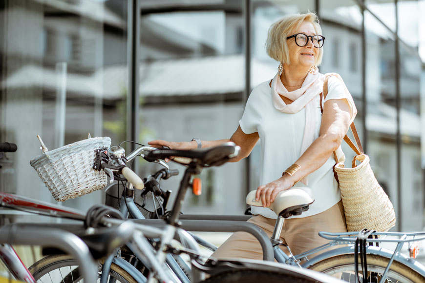 An older woman parks her bicycle while doing her regular errands