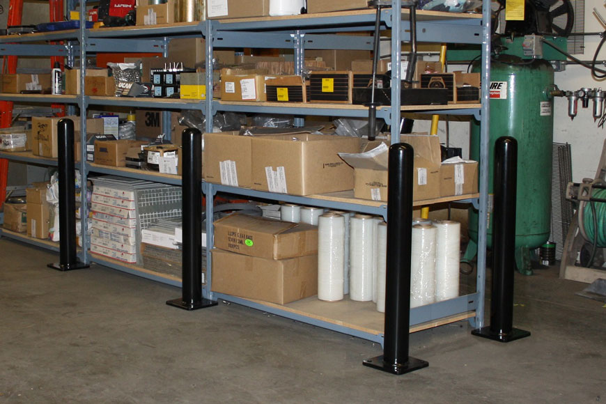 Bolt-down asset protecting bollards surround a warehouse shelving unit