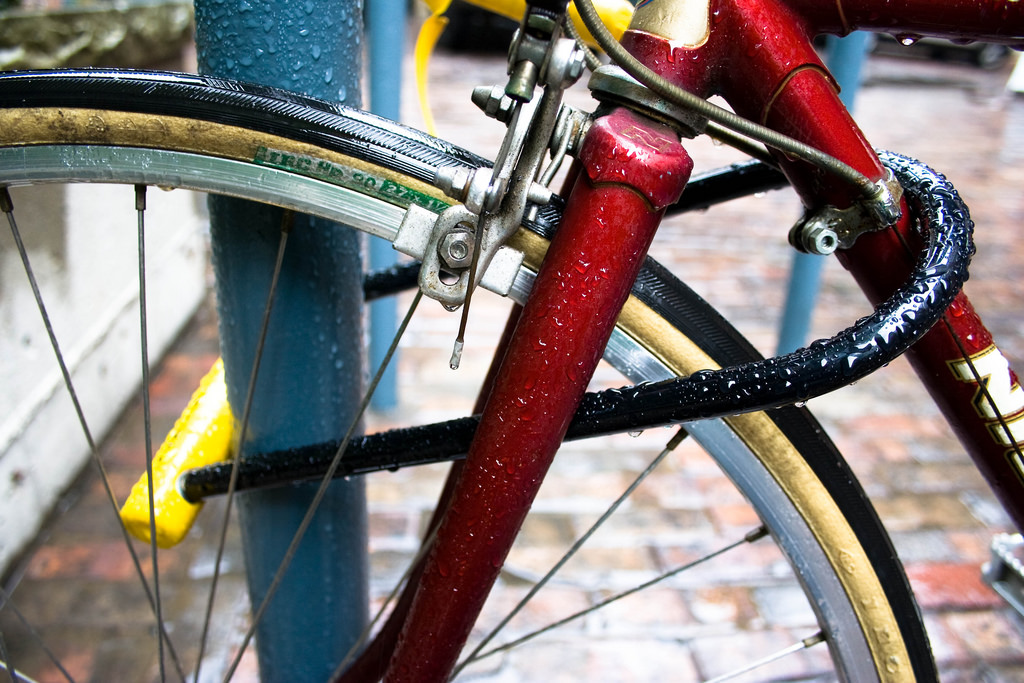 red bicycle properly locked with u-lock close up