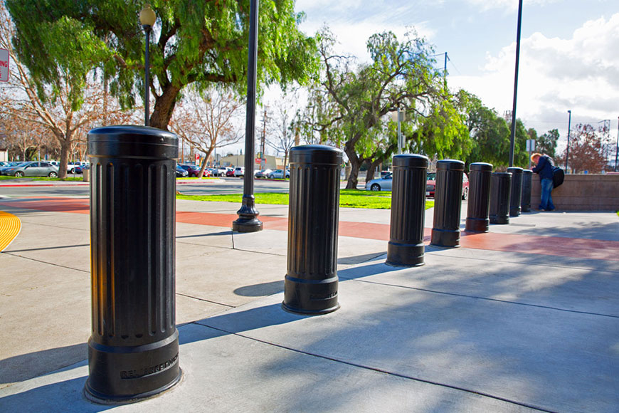 black bollards along sidewalk near parking lot