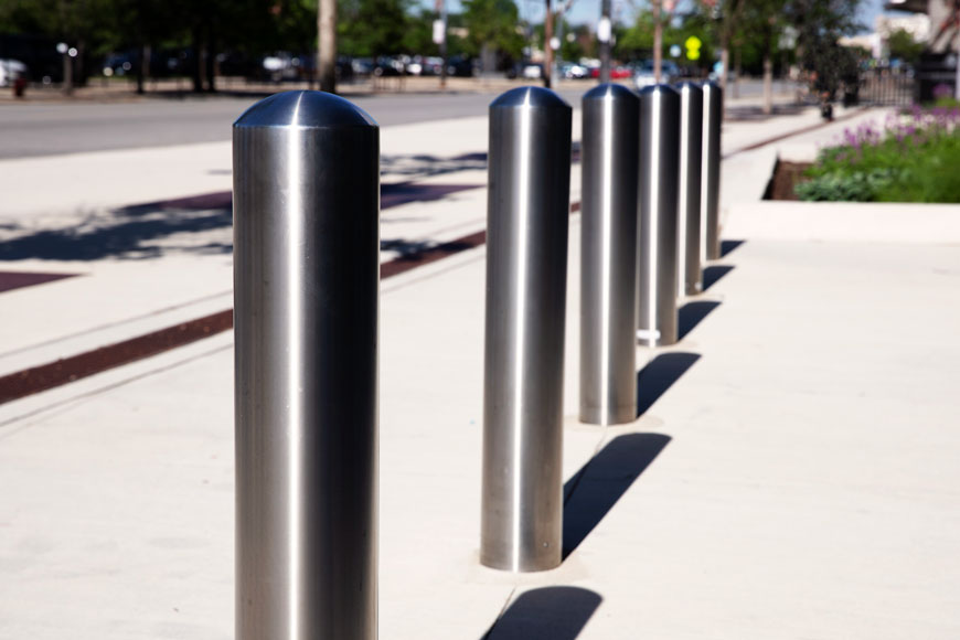 Man walking past stainless steel bollards