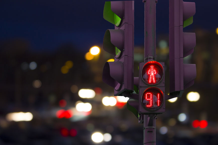 A don’t walk symbol on a street light shows 91 seconds left on a timer, scene at night