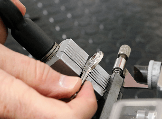 locksmith cutting a silver key